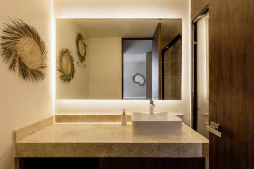 a bathroom with a sink and a mirror at Itzel Samsara Dream Penthouse in Tulum