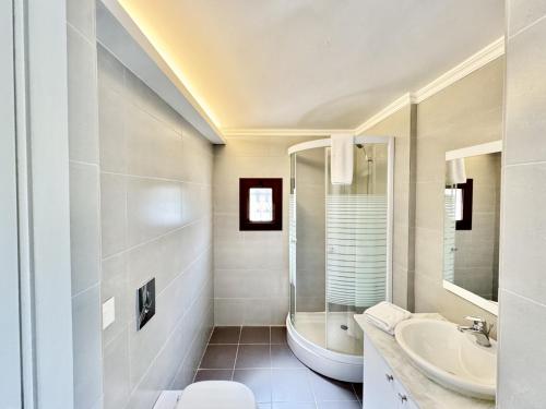 a white bathroom with a sink and a tub at Amelia Duplex 3-BR in Faraya in Fārayyā