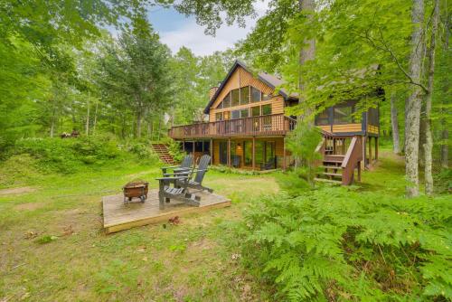 a large wooden house in the middle of a forest at Cozy Wisconsin Cabin with Deck, Kayaks and Lake Views! in Hayward