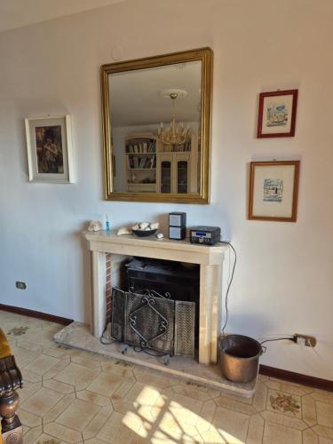 a living room with a fireplace and a mirror at Villa la Gravina in Statte