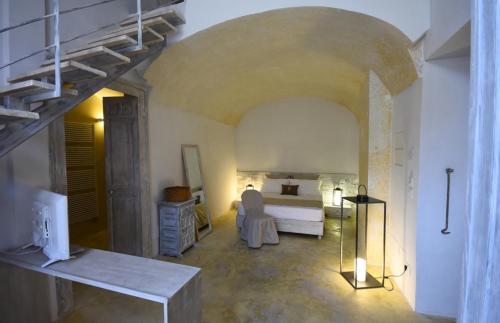 a bedroom with a bed and a staircase in a room at Palazzo Castriota in Alezio
