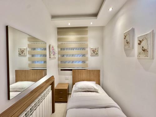 a bedroom with two beds and a mirror at Sapa - 2-BR w Terrace in Faraya in Fārayyā