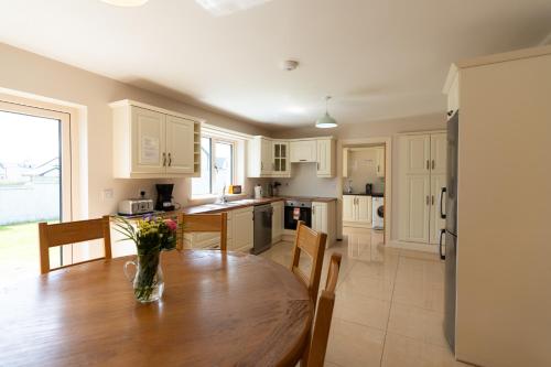 a kitchen with a wooden table with a vase of flowers on it at No 59 - Luxury Townhouse Dingle in Dingle
