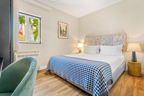 Un dormitorio con una cama y una silla verde. en Casa do Patio by Shiadu, en Lisboa