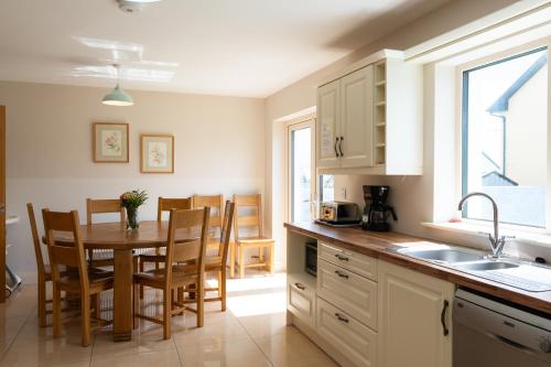 a kitchen with a table and chairs and a sink at No 59 - Luxury Townhouse Dingle in Dingle