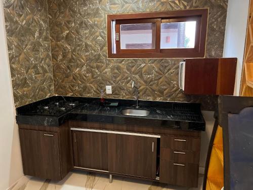 a kitchen with a sink and a counter top at 4let Chalés Sonho de Verão in São Miguel do Gostoso