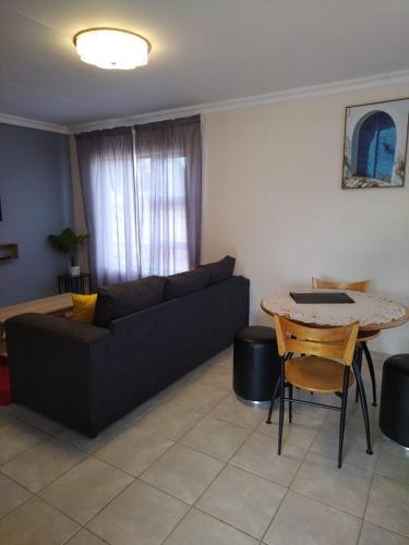 a living room with a couch and a table at MV self-catering 3 Units in Bloemfontein