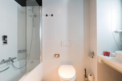 a bathroom with a toilet and a shower at Leonardo Hotel Almere City Center in Almere