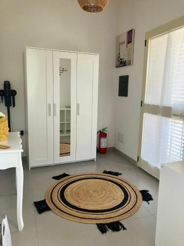 a room with a large rug on the floor next to a cabinet at Casa Ulivo in San Sperate