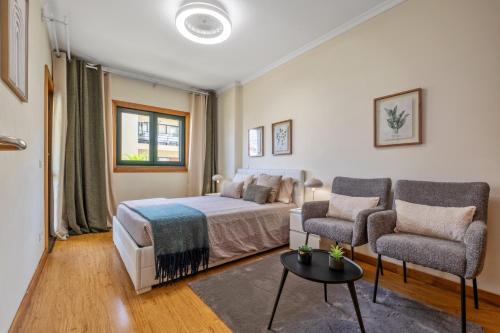 a bedroom with a bed and two chairs at Vintage in Funchal