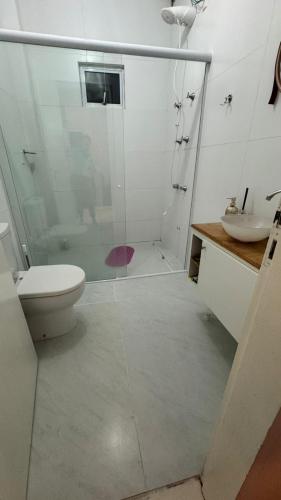 a bathroom with a shower and a toilet and a sink at Hospedagem Vô João in Gravatal