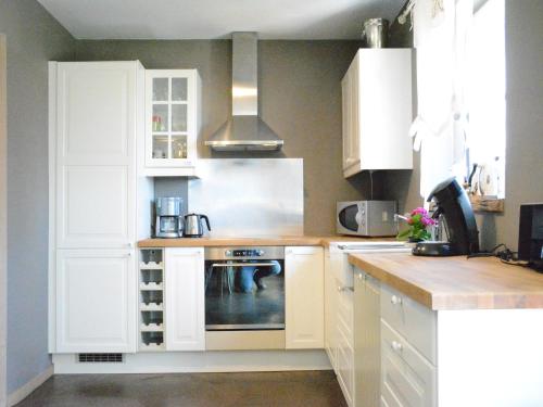 a kitchen with white cabinets and a stove at Forest Cottage, Jehonville in Jehonville