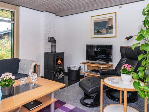 a living room with a couch and a fireplace at 6 person holiday home in Ebeltoft-By Traum in Ebeltoft