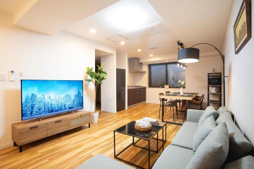 a living room with a large flat screen tv at 電車で新宿まで10分3ldk2個トイレ2個シャワー室無料駐車場庭付き in Tokyo
