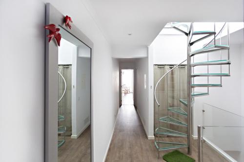 eine Wendeltreppe aus Glas in einem weißen Zimmer mit Flur in der Unterkunft Casa da Vila in Faro