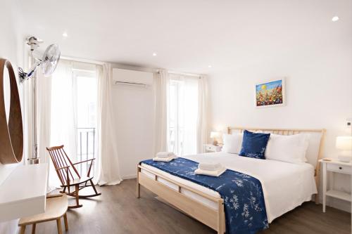 ein weißes Schlafzimmer mit einem großen Bett und einem Schreibtisch in der Unterkunft Casa da Vila in Faro