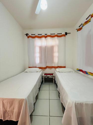 Dos camas en una habitación con ventana. en Xicabacana, en Mata de Sao Joao