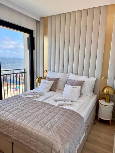 a bedroom with a large bed with a view of the ocean at Baltic Infinity Resort&Spa Apartament Dworek in Międzyzdroje