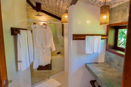 a bathroom with white towels hanging on a wall at Aketá Hotel Boutique in Trancoso