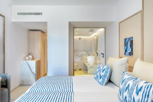 a bedroom with a bed with blue and white pillows at Hotel Vibra Yamm Sunset -New Opening 2025 in San Antonio