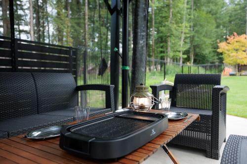 an outdoor table with a laptop on top of it at Pino-富士山麓-山中湖-新築貸切ヴィラ-蚊帳東屋BBQ無料-150平米ドッグラン付-小型犬3匹無料-長期滞在早期歓迎割引-バリアフリー in Yamanakako
