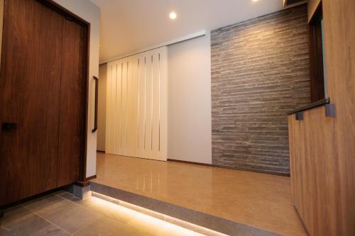 a hallway with doors and a brick wall at Pino-富士山麓-山中湖-新築貸切ヴィラ-蚊帳東屋BBQ無料-150平米ドッグラン付-小型犬3匹無料-長期滞在早期歓迎割引-バリアフリー in Yamanakako
