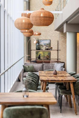 a restaurant with wooden tables and chairs in a room at Comwell Rebild Bakker in Skorping