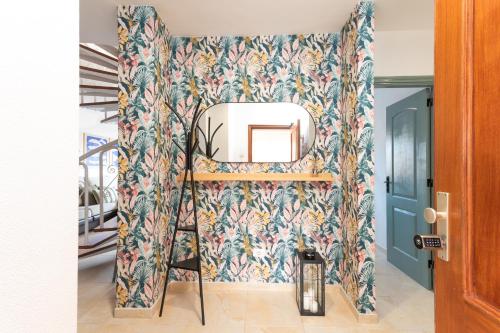 a mirror on a wall with a floral wallpaper at Profithome- Brisas de Güimar in Puertito de Güímar