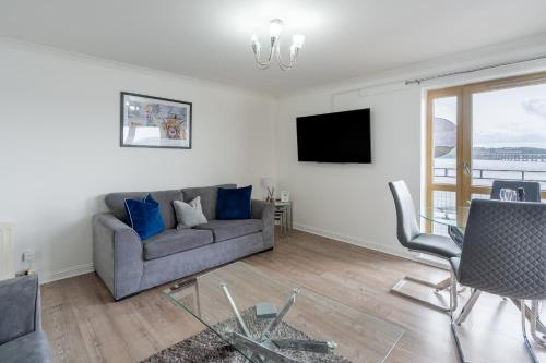 a living room with a couch and a tv at Casa Fresa - City Quay Apartment in Dundee