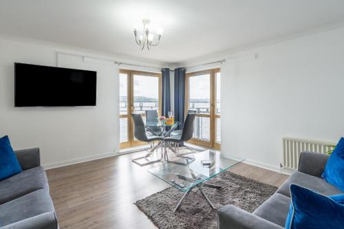 a living room with a couch and a table with chairs at Casa Fresa - City Quay Apartment in Dundee