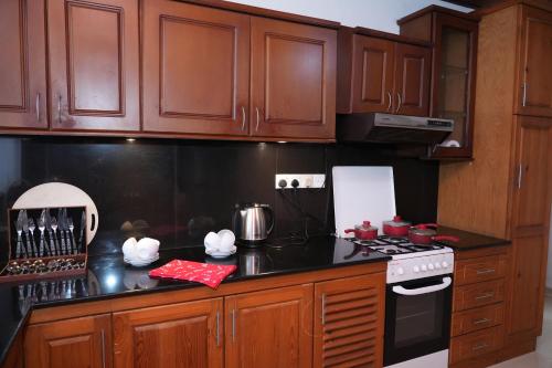 a kitchen with wooden cabinets and a stove top oven at The Mist Residence - Kandy in Kandy