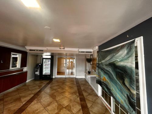 a hallway with a large painting on the wall at Capital O Kings Inn in Memphis