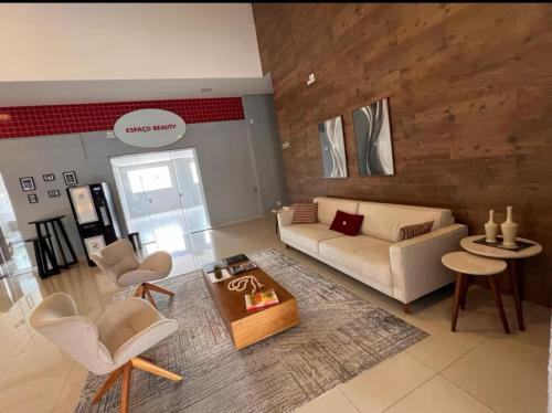 a living room with a couch and chairs and a table at Loft aconchegante com varanda Campolim in Sorocaba