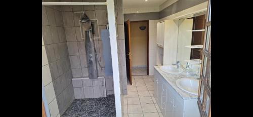 une salle de bain avec deux lavabos et une douche dans l'établissement Maison au milieu des vignes, à Moroges