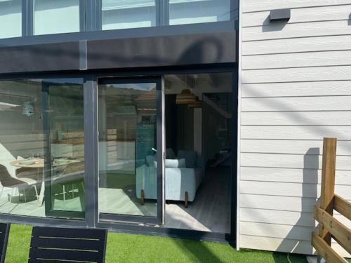 a house with sliding glass doors on the side of it at Apartamentos Catamarán Azul in Suances