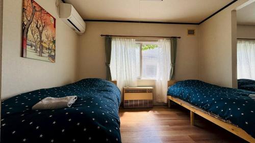 a bedroom with two beds and a window at SecondHouse Green in Otaru