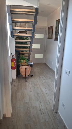 a hallway with a staircase with a wooden floor at B&B Brezza Marina in Roccalumera