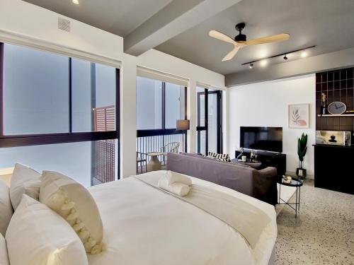 a bedroom with a large white bed and a couch at Brand new, luxury, wifi, pool with 24hr security in Cape Town