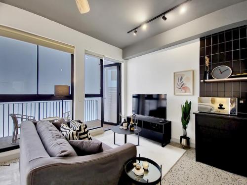 a living room with a large couch and a balcony at Brand new, luxury, wifi, pool with 24hr security in Cape Town