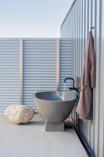 a bathroom with a stone tub and a rock at RESET Hotel Joshua Tree in Twentynine Palms