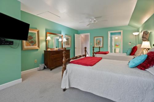 a bedroom with two beds and a flat screen tv at Ruthie's Roost villa by Peace Vacations in Georgetown