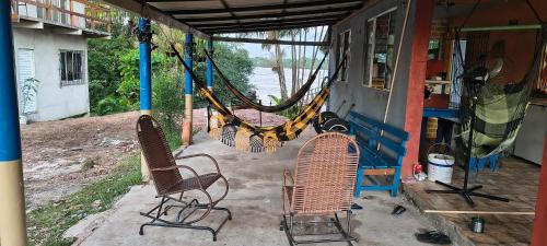 twee stoelen en een hangmat buiten een huis bij Casa aconchegante em cotijuba in Ilha Paquetá-Açu