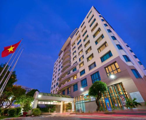 a hotel with a flag in front of a building at Garden Plaza Saigon - Formerly PARKROYAL Saigon in Ho Chi Minh City