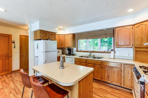 a kitchen with wooden cabinets and a white refrigerator at Waterfront Home on Duck Lake 8 Mi to State Park! in Grawn