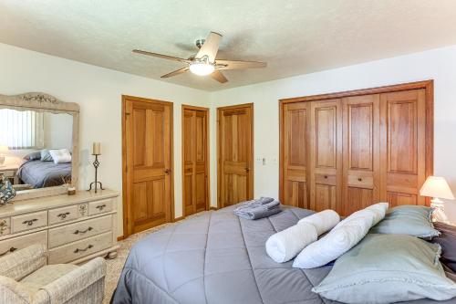 a bedroom with a large bed with a ceiling fan at Waterfront Home on Duck Lake 8 Mi to State Park! in Grawn