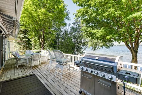 a grill on a deck with a table and chairs at Waterfront Home on Duck Lake 8 Mi to State Park! in Grawn