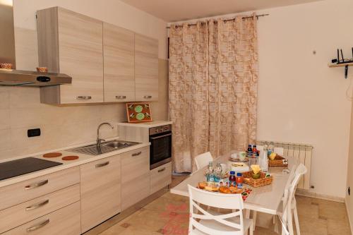 a kitchen with a table and a sink and a table and chairs at B&B Il Rifugio di Olea in Picerno