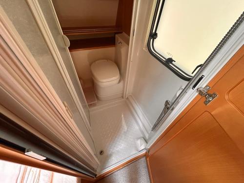 a small bathroom with a toilet in a room at Lazy Days Caravan in Berlin
