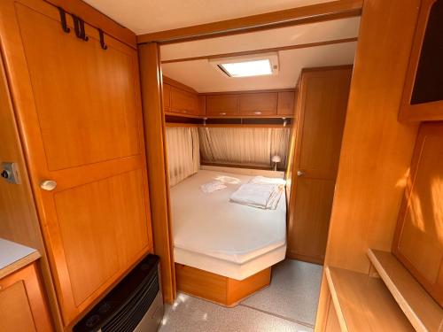 a small room with a small bed in it at Lazy Days Caravan in Berlin