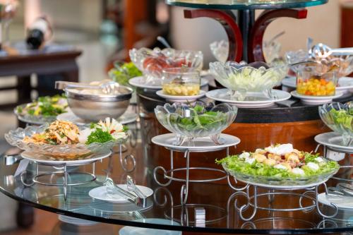 a buffet with plates of food on a glass table at Garden Plaza Saigon - Formerly PARKROYAL Saigon in Ho Chi Minh City